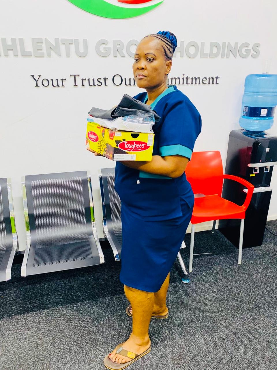 A recipient holding a box of donated school shoes