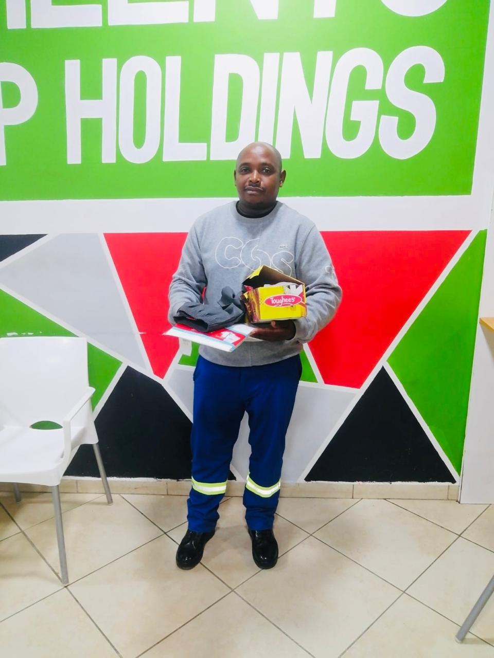A community member holding donated school shoes